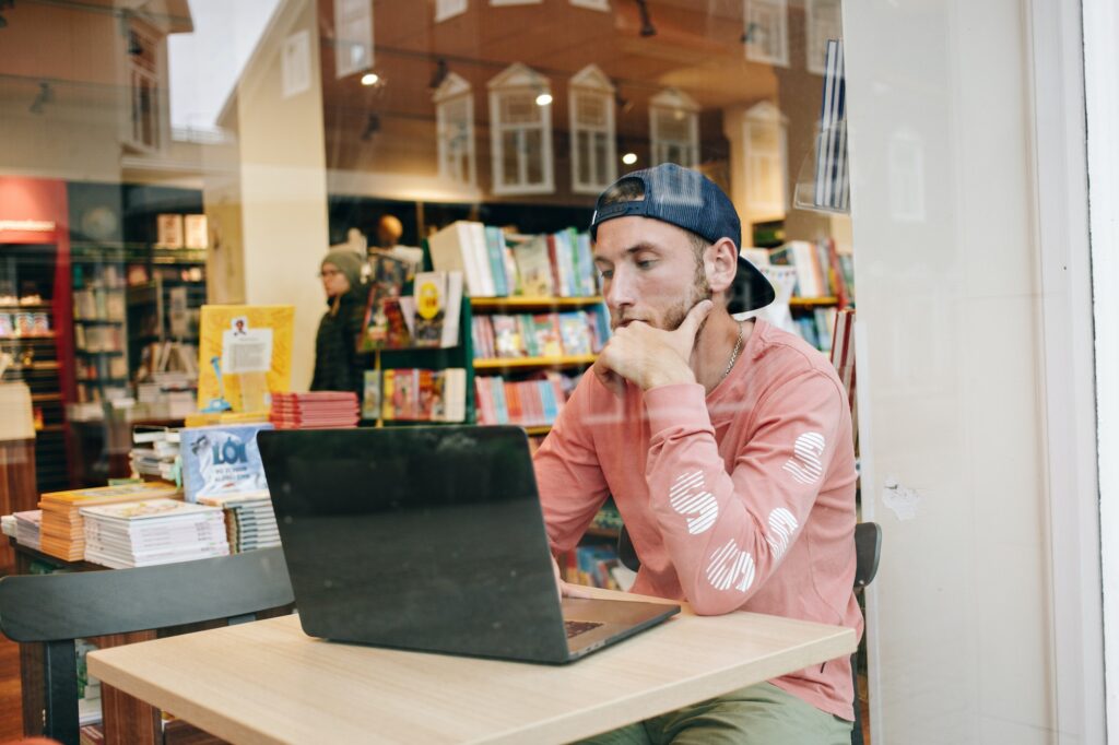 Man work on laptop in cafe window